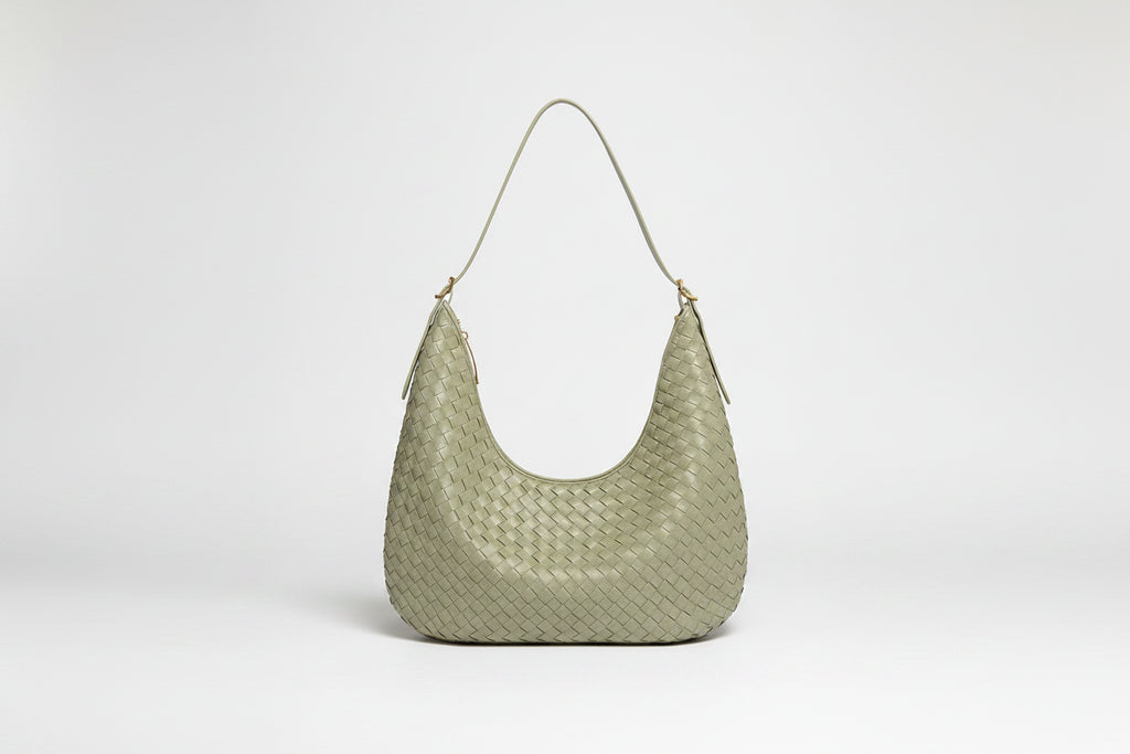 Light green woven handbag on a white background