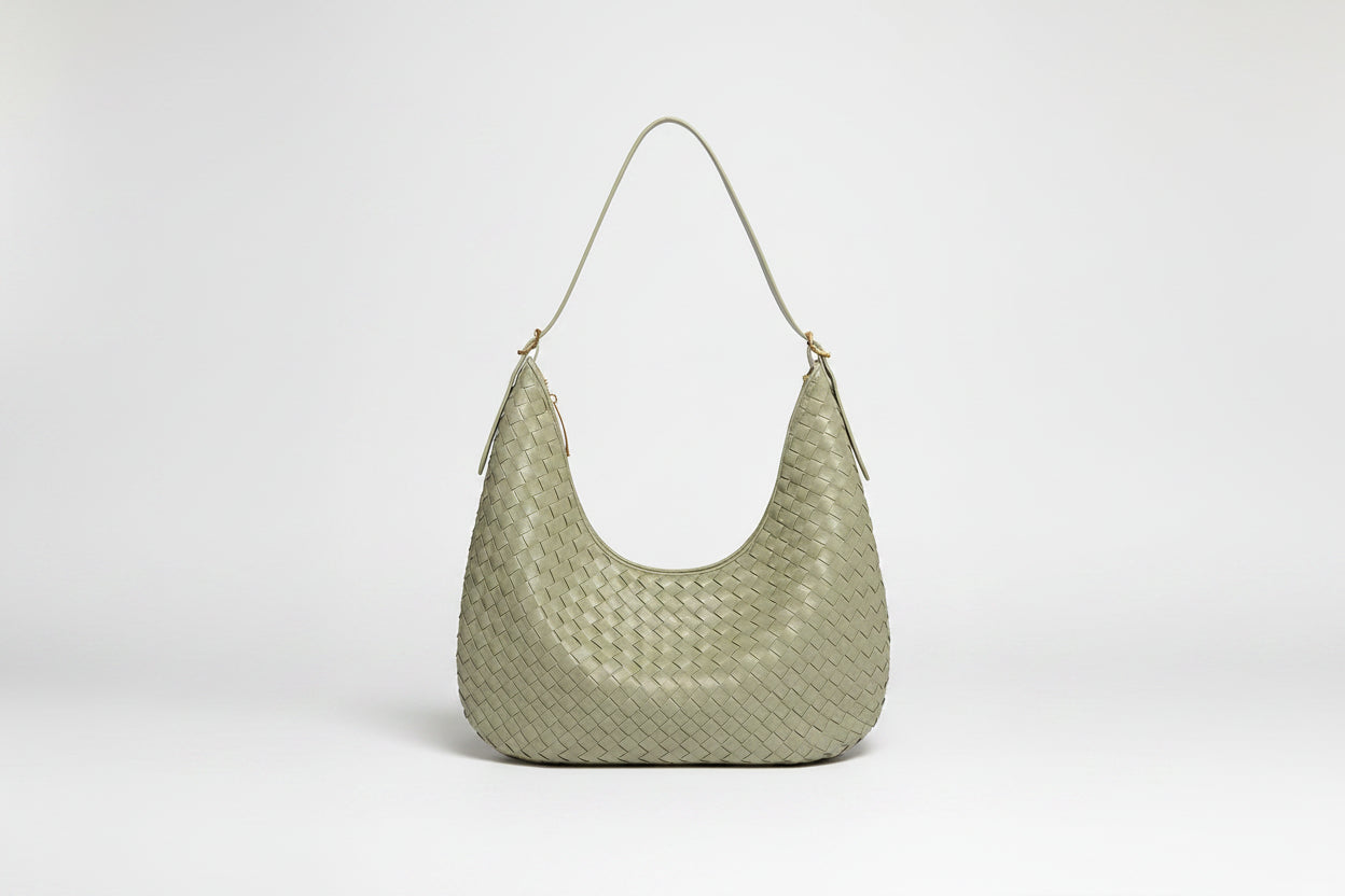 Light green woven handbag on a white background