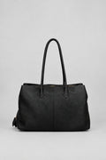 A black leather tote bag with two top handles, photographed against a neutral light gray background.