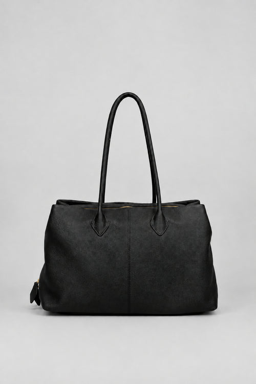 A black leather tote bag with two top handles, photographed against a neutral light gray background.